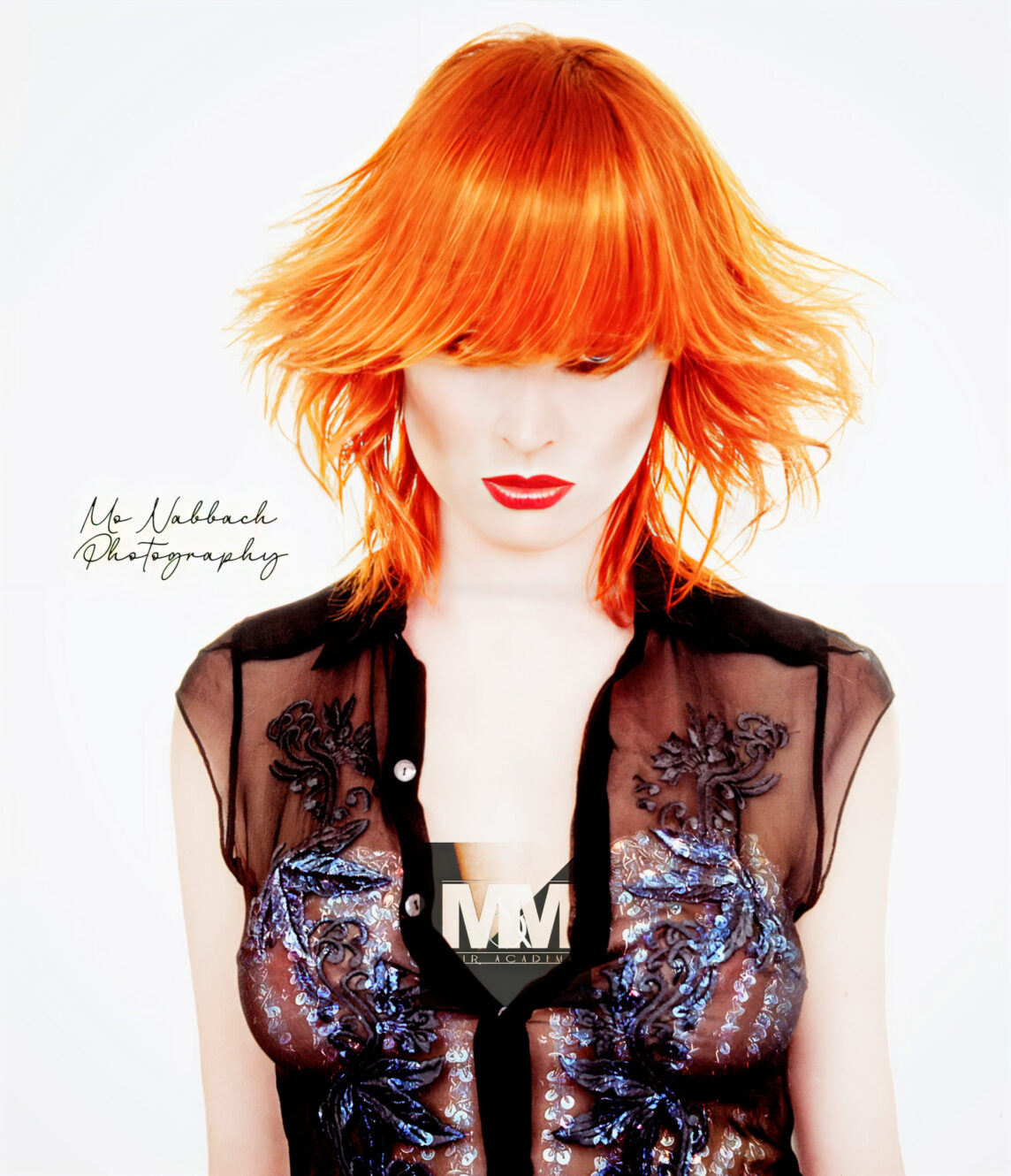 Front view of a woman with a copper gold butterfly bob haircut styled in soft, airy layers