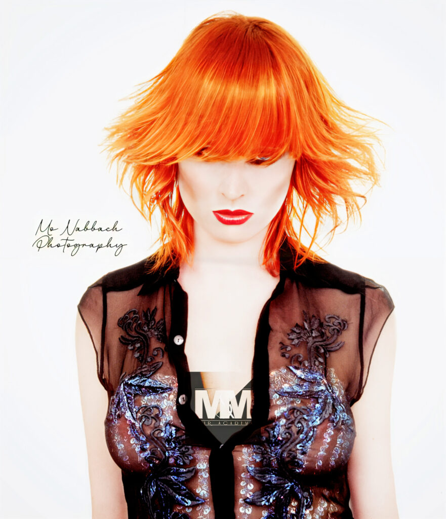 Front view of a woman with a copper gold butterfly bob haircut styled in soft, airy layers